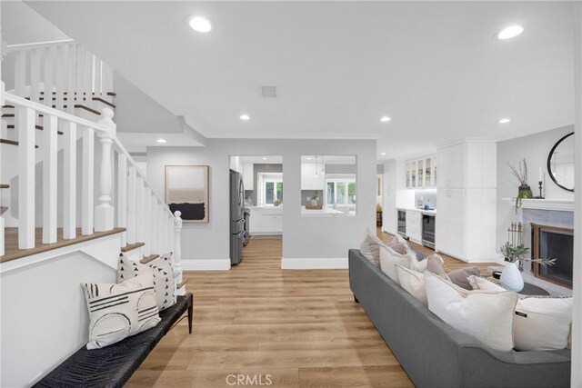 12012 Paseo Bonita, Los Alamitos, CA 90720 - living area featuring stairway, recessed lighting, light wood-style flooring, wine cooler, and crown molding