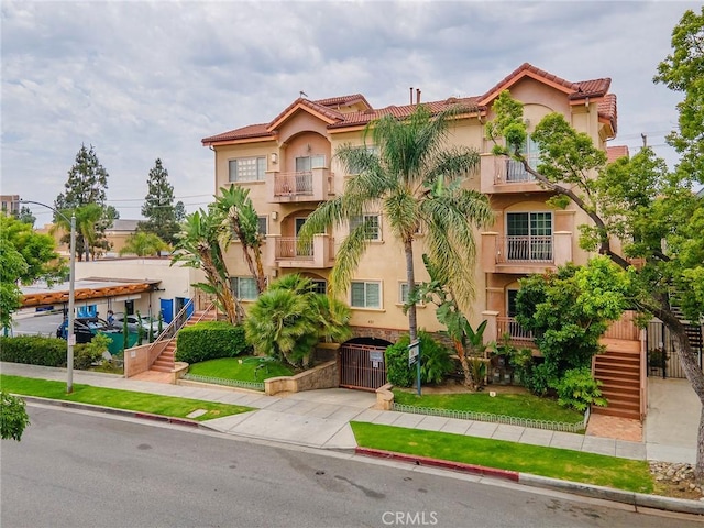 421 E Santa Anita Ave Unit 101, Burbank, CA 91501 - view of front facade featuring stucco siding, stairs, a tiled roof, and a gate