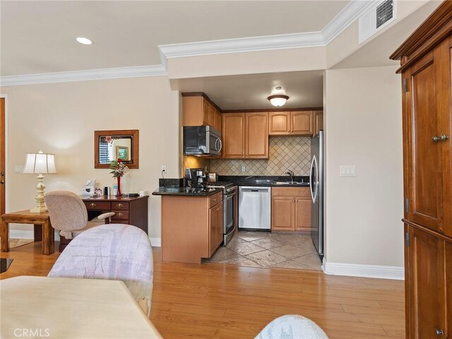 421 E Santa Anita Ave Unit 101, Burbank, CA 91501 - kitchen featuring appliances with stainless steel finishes, ornamental molding, tasteful backsplash, dark countertops, and light wood-style flooring