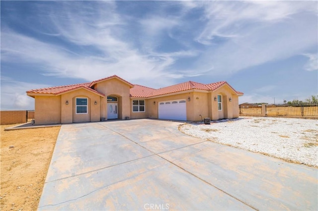 9600 S Loop Blvd, California City, CA 93505 - mediterranean / spanish house with an attached garage, stucco siding, driveway, and a tile roof