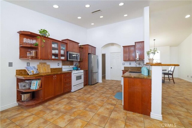 9600 S Loop Blvd, California City, CA 93505 - kitchen featuring appliances with stainless steel finishes, open shelves, a peninsula, dark stone countertops, and recessed lighting