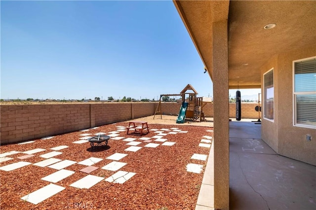 9600 S Loop Blvd, California City, CA 93505 - fenced backyard with a playground, an outdoor fire pit, and a patio