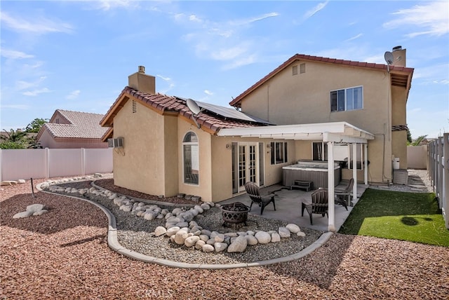 13180 Meteor Dr, Victorville, CA 92395 - rear view of property featuring a hot tub, a chimney, french doors, a fire pit, and a fenced backyard