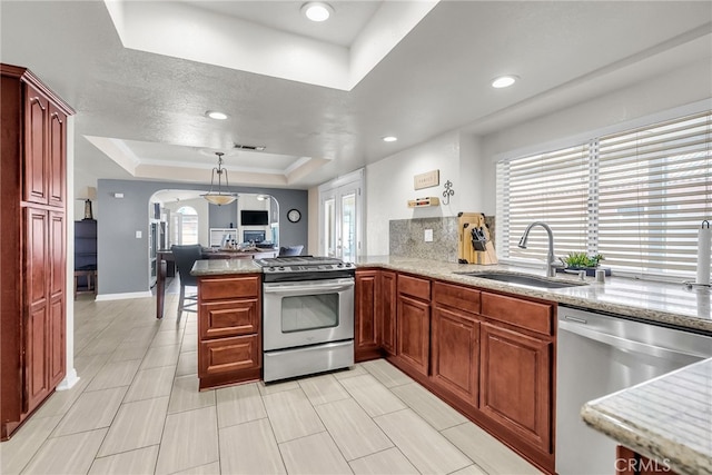 13180 Meteor Dr, Victorville, CA 92395 - kitchen with stainless steel appliances, a tray ceiling, arched walkways, a peninsula, and open floor plan