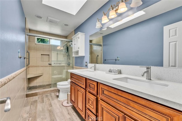1719 Turnbull Canyon Rd, Hacienda Heights, CA 91745 - bathroom with a stall shower, double vanity, wood finished floors, and a skylight