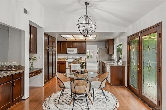 4772 Gateshead Rd, Carlsbad, CA 92010 - dining area with a chandelier, lofted ceiling, and light wood-style flooring