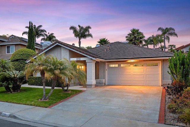 4772 Gateshead Rd, Carlsbad, CA 92010 - view of front facade featuring a garage, concrete driveway, a tile roof, a lawn, and stucco siding