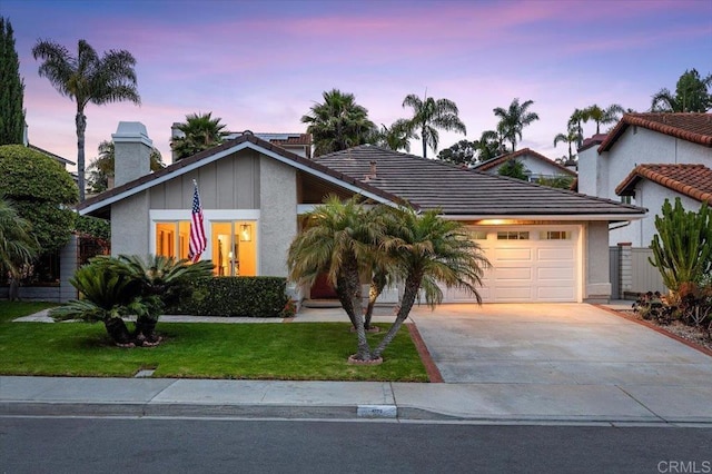 4772 Gateshead Rd, Carlsbad, CA 92010 - view of front of property featuring driveway, an attached garage, a front yard, a chimney, and stucco siding