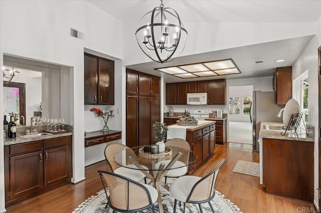 4772 Gateshead Rd, Carlsbad, CA 92010 - dining room featuring a chandelier, a towering ceiling, and wood finished floors