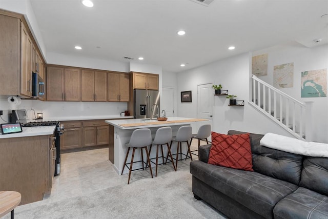 39381 Corvina Ln, Temecula, CA 92591 - kitchen with appliances with stainless steel finishes, open floor plan, a kitchen breakfast bar, recessed lighting, and light countertops