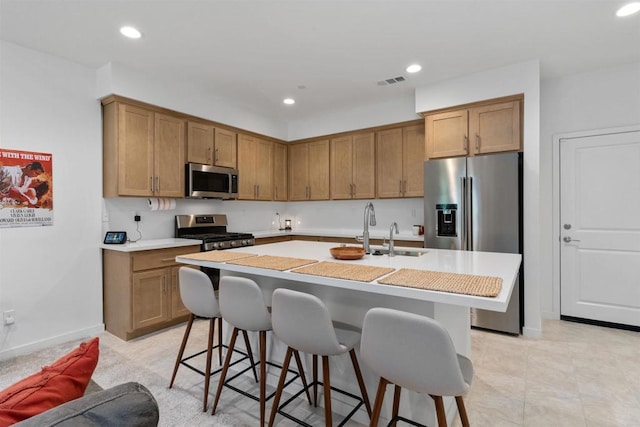 39381 Corvina Ln, Temecula, CA 92591 - kitchen with appliances with stainless steel finishes, a kitchen breakfast bar, light countertops, recessed lighting, and a kitchen island with sink