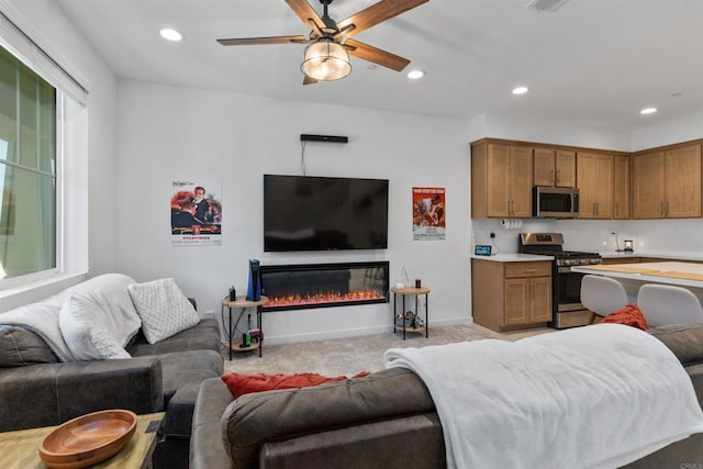 39381 Corvina Ln, Temecula, CA 92591 - living room featuring ceiling fan, recessed lighting, light colored carpet, and a glass covered fireplace