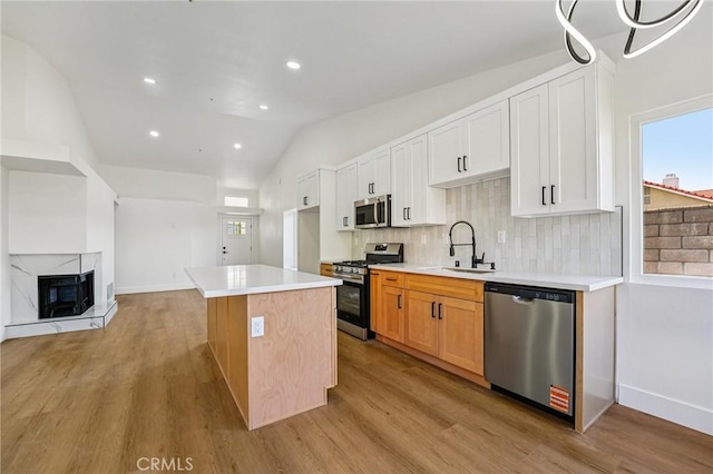 7652 Plumaria, Fontana, CA 92336 - kitchen with stainless steel appliances, lofted ceiling, light wood-type flooring, light countertops, and backsplash