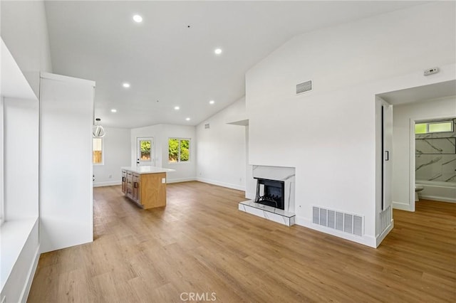 7652 Plumaria, Fontana, CA 92336 - living area with light wood-style floors, recessed lighting, a fireplace with raised hearth, and high vaulted ceiling