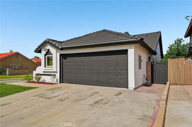 7652 Plumaria, Fontana, CA 92336 - view of front facade with a gate, a garage, driveway, a tile roof, and stucco siding