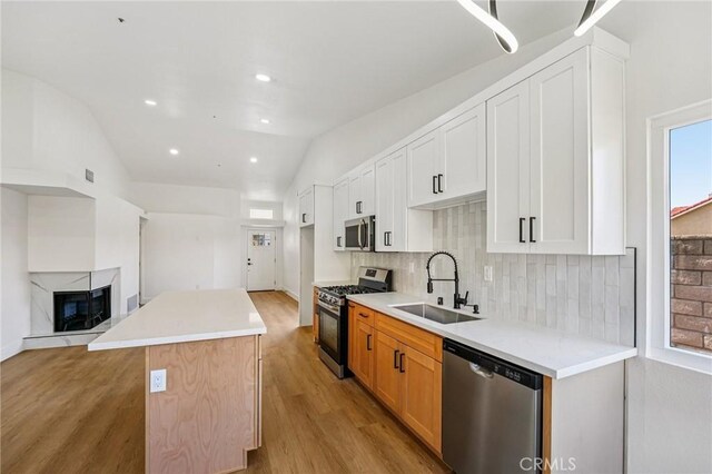 7652 Plumaria, Fontana, CA 92336 - kitchen with stainless steel appliances, tasteful backsplash, a center island, light wood-type flooring, and light countertops