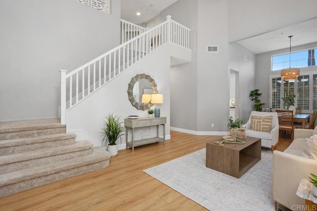 3071 Sprucewood Ln, Escondido, CA 92027 - living room with a towering ceiling, a chandelier, stairs, and wood finished floors