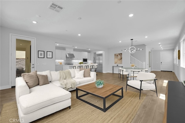 9876 Skylar Ave, Fountain Valley, CA 92708 - living room featuring light wood finished floors, recessed lighting, a chandelier, and stairway