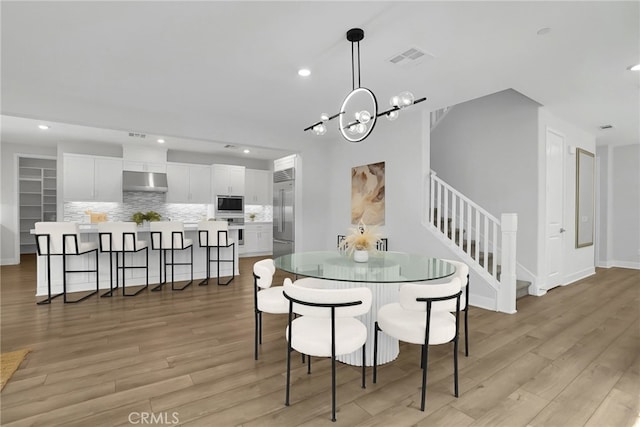 9876 Skylar Ave, Fountain Valley, CA 92708 - dining room featuring light wood finished floors, stairs, recessed lighting, and a chandelier
