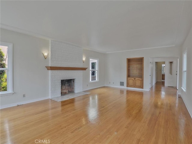1017 Cordova Ave, Glendale, CA 91207 - unfurnished living room with light wood-style floors, built in features, and a brick fireplace