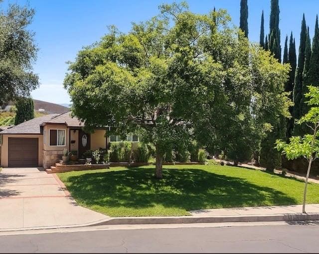 14658 Maclay St, San Fernando, CA 91345 - view of front facade featuring a garage, a front lawn, driveway, and stucco siding