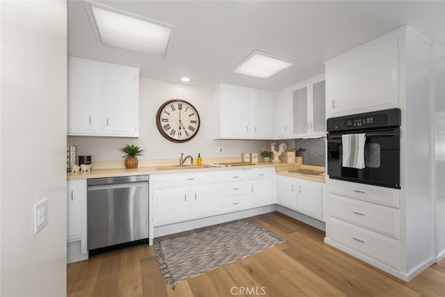 1661 Monterey Rd Unit 16G, Seal Beach, CA 90740 - kitchen with black oven, dishwasher, white cabinetry, light countertops, and recessed lighting