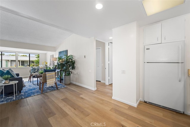 1661 Monterey Rd Unit 16G, Seal Beach, CA 90740 - kitchen featuring freestanding refrigerator, light wood-style flooring, white cabinets, and recessed lighting