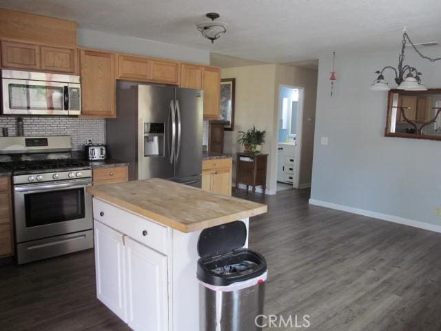 14537 Yucca St, Hesperia, CA 92345 - kitchen featuring appliances with stainless steel finishes, dark wood finished floors, decorative backsplash, a kitchen island, and butcher block counters