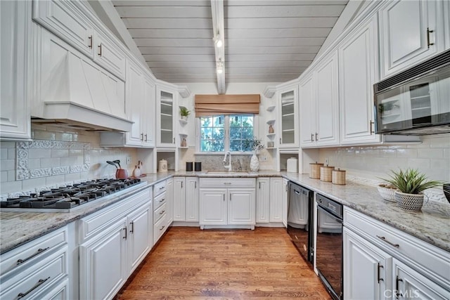 9472 Rembert Ln, Beverly Hills, CA 90210 - kitchen with black microwave, stainless steel gas stovetop, rail lighting, white cabinetry, and a wood ceiling with exposed beams