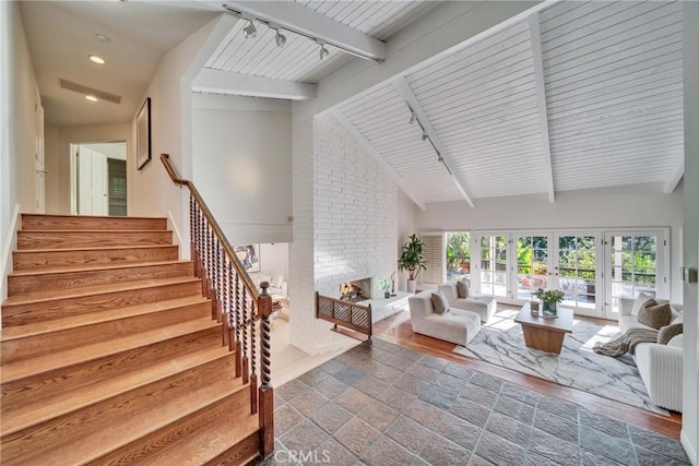 9472 Rembert Ln, Beverly Hills, CA 90210 - living room with a fireplace, stairs, beamed ceiling, rail lighting, and french doors