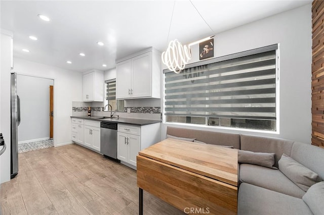 2121 E 1st St Unit 108, Long Beach, CA 90803 - kitchen featuring dishwasher, recessed lighting, dark countertops, light wood-type flooring, and white cabinets