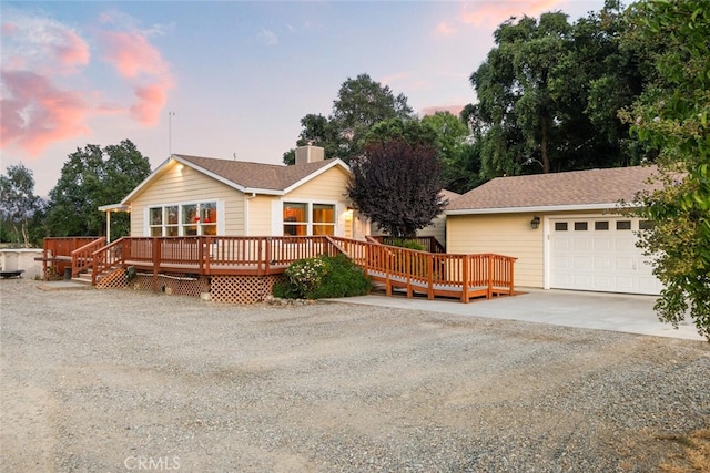 24825 Florence Ave, Corning, CA 96021 - view of front of home with driveway, a deck, a garage, and a chimney