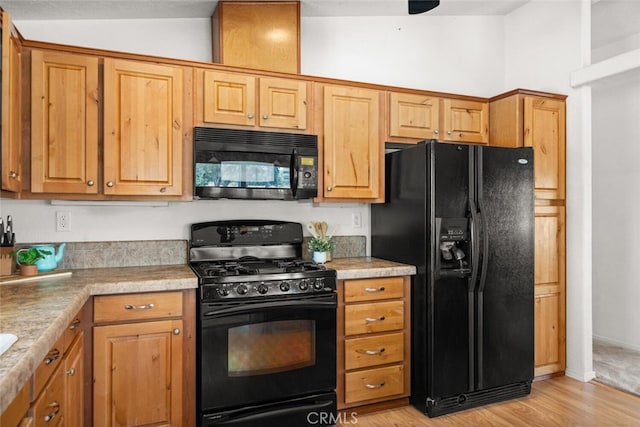 24825 Florence Ave, Corning, CA 96021 - kitchen featuring black appliances, light wood finished floors, light countertops, and vaulted ceiling
