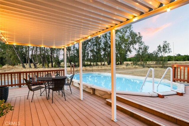 24825 Florence Ave, Corning, CA 96021 - wooden terrace featuring outdoor dining space, an outdoor pool, and view of scattered trees
