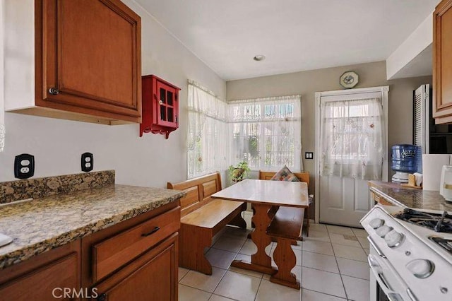 665 N Waterbury Ave, Covina, CA 91722 - kitchen featuring gas range gas stove, light tile patterned flooring, brown cabinets, and glass insert cabinets