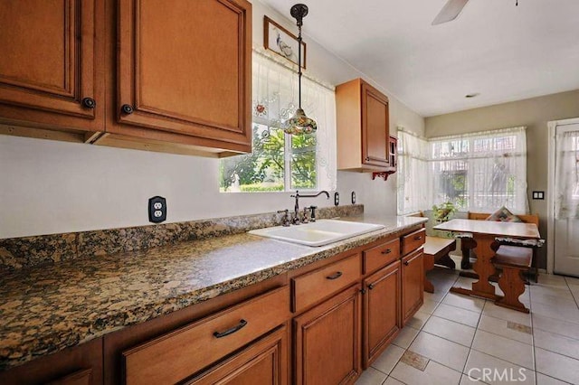 665 N Waterbury Ave, Covina, CA 91722 - kitchen with brown cabinetry, light tile patterned floors, decorative light fixtures, and dark countertops