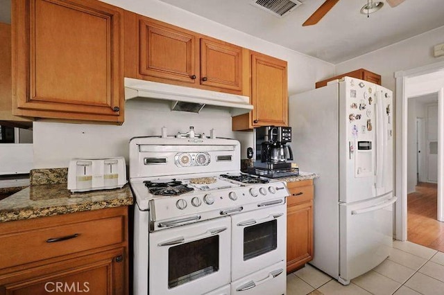 665 N Waterbury Ave, Covina, CA 91722 - kitchen with white appliances, under cabinet range hood, a ceiling fan, light tile patterned floors, and brown cabinetry