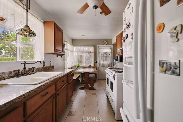 665 N Waterbury Ave, Covina, CA 91722 - kitchen with white appliances, healthy amount of natural light, light tile patterned floors, and brown cabinetry