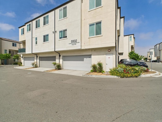 5502 Caminito Sandwaves Unit 173, San Diego, CA 92154 - view of front facade with stucco siding and a garage