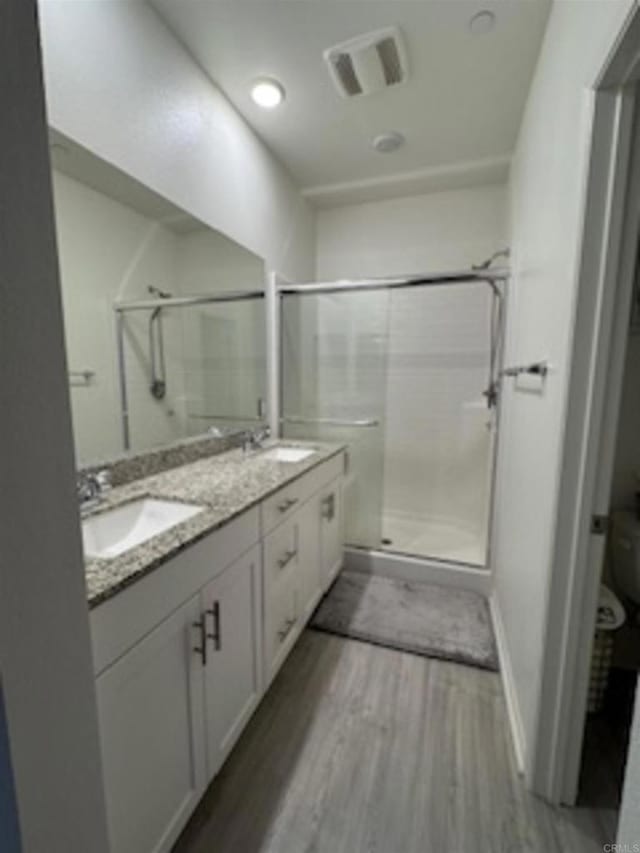 5502 Caminito Sandwaves Unit 173, San Diego, CA 92154 - full bathroom with wood finished floors, a shower stall, and double vanity