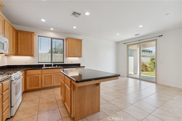 843 Sydney Way, Lemoore, CA 93245 - kitchen with white range with gas stovetop, a kitchen island, dark countertops, recessed lighting, and a kitchen bar