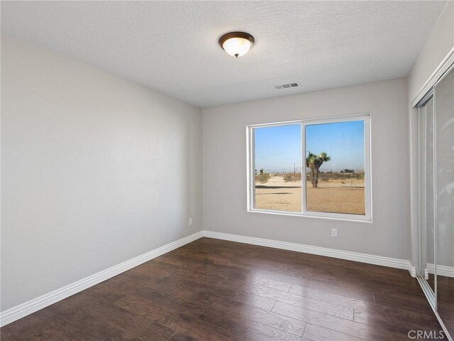 7755 7th St, Phelan, CA 92371 - spare room featuring dark wood-type flooring and baseboards