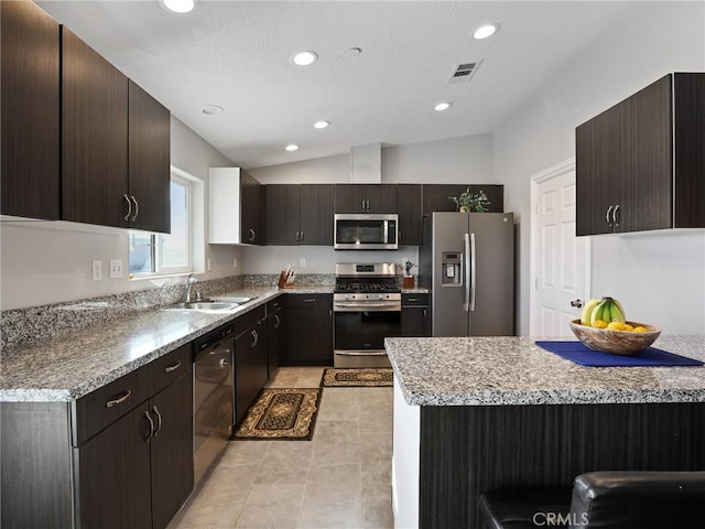 7755 7th St, Phelan, CA 92371 - kitchen with stainless steel appliances, lofted ceiling, dark brown cabinets, recessed lighting, and light tile patterned floors