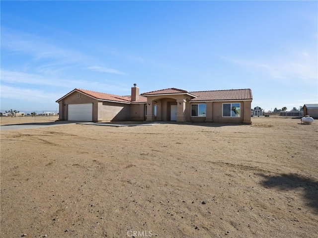 7755 7th St, Phelan, CA 92371 - view of front facade featuring an attached garage, a chimney, a tiled roof, driveway, and stucco siding