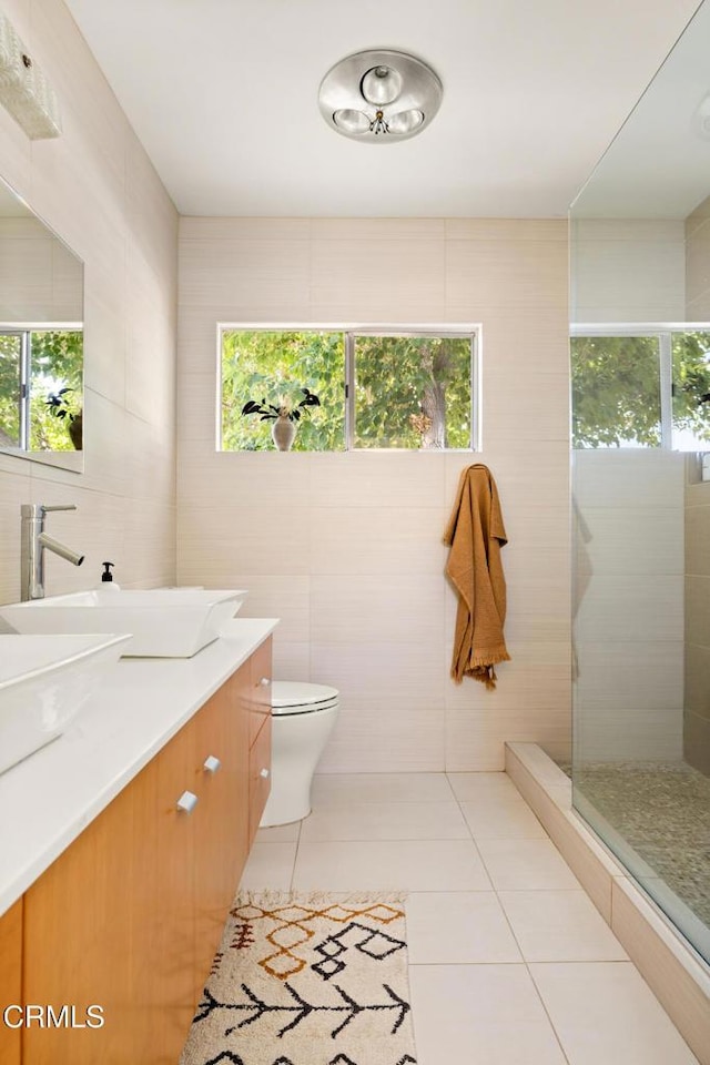54667 Benecia Trl, Yucca Valley, CA 92284 - full bath with vanity, tile walls, plenty of natural light, and tile patterned floors