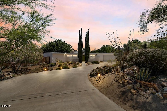 54667 Benecia Trl, Yucca Valley, CA 92284 - view of front of house with concrete driveway, a garage, and stucco siding