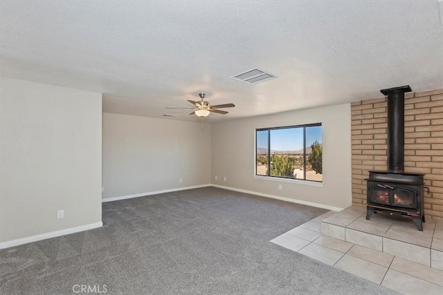 7267 Dalscote St, Hesperia, CA 92345 - unfurnished living room featuring carpet floors, a wood stove, ceiling fan, and a textured ceiling
