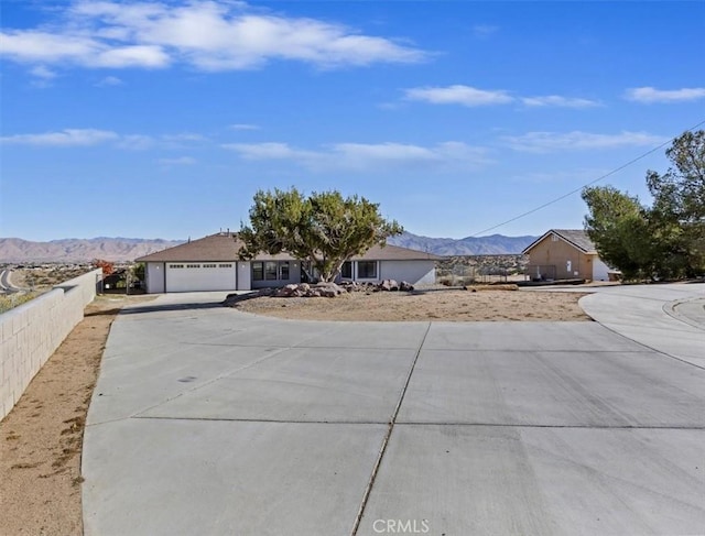 7267 Dalscote St, Hesperia, CA 92345 - view of front of house with concrete driveway, a mountain view, and an attached garage
