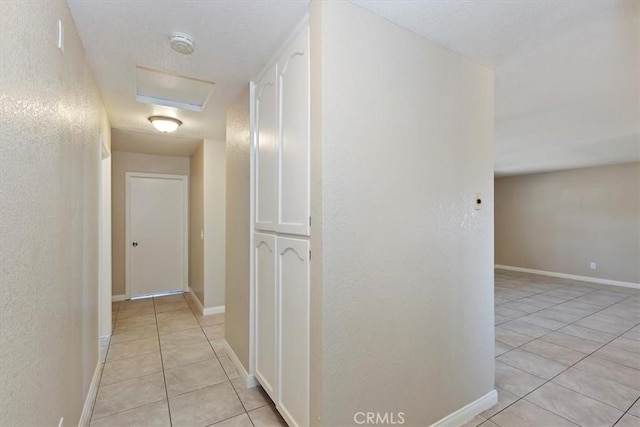 7267 Dalscote St, Hesperia, CA 92345 - hallway with light tile patterned flooring, a textured wall, and attic access