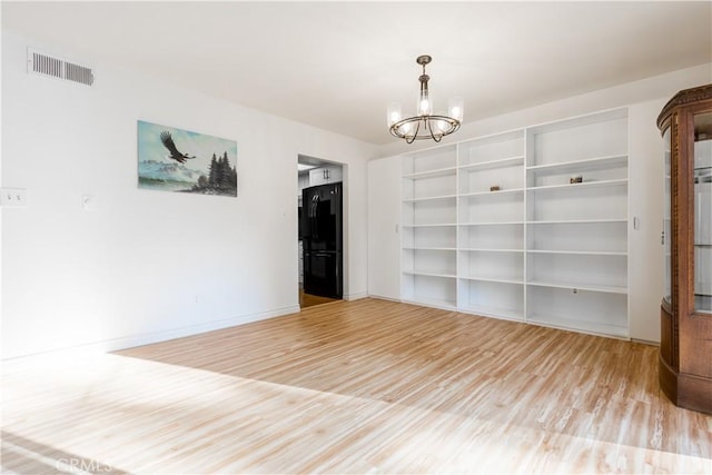 966 Willow Creek Rd Unit 14, Lake Arrowhead, CA 92352 - empty room with wood finished floors and a chandelier